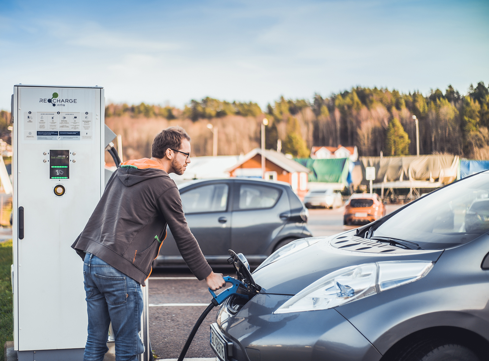 Mann som fyller bensin på bilen sin